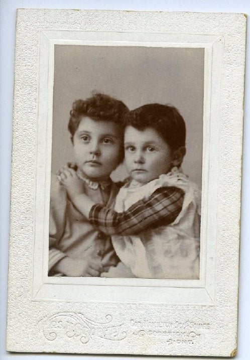 Black & white image of two children embracing.