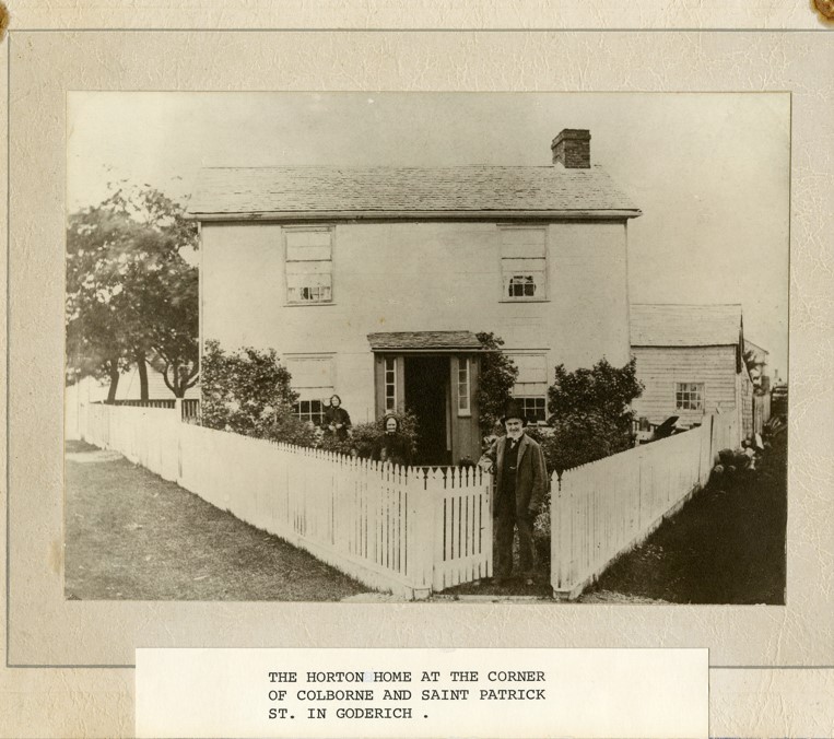 Historic image of a home with people standing in the yard - taken in Goderich