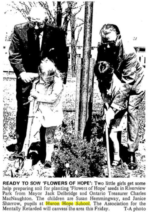 Newspaper clipping showing photo of two girls with shovels planting flowers at the Huron School of Hope