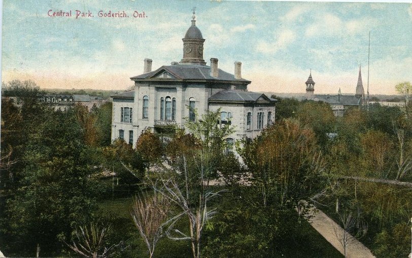 Colour postcard of Huron County Courthouse located in Goderich Square, surrounded by trees. Nineteenth century. 