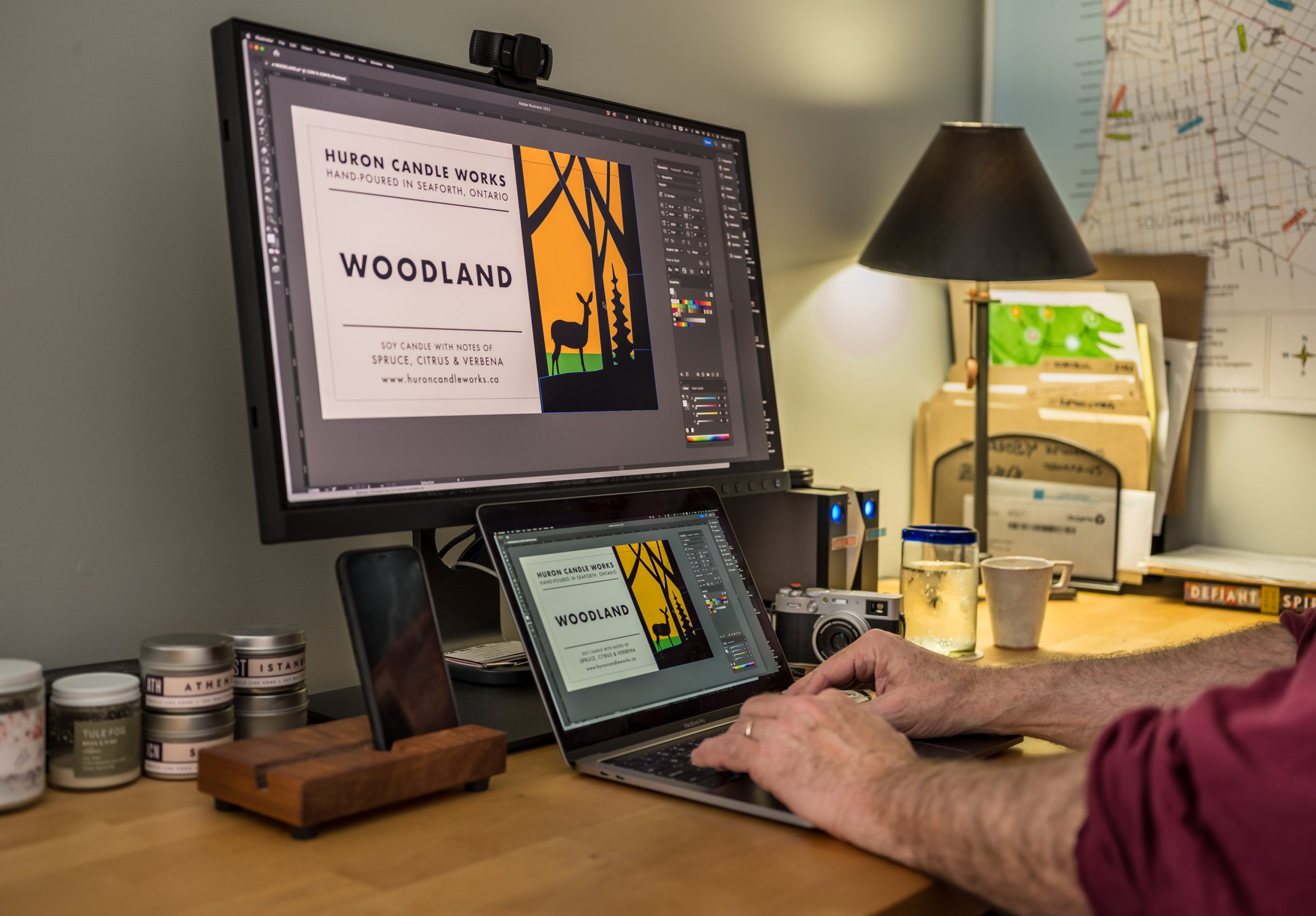 Photo of a computer screen with hands at a keyboard creating candle label design.