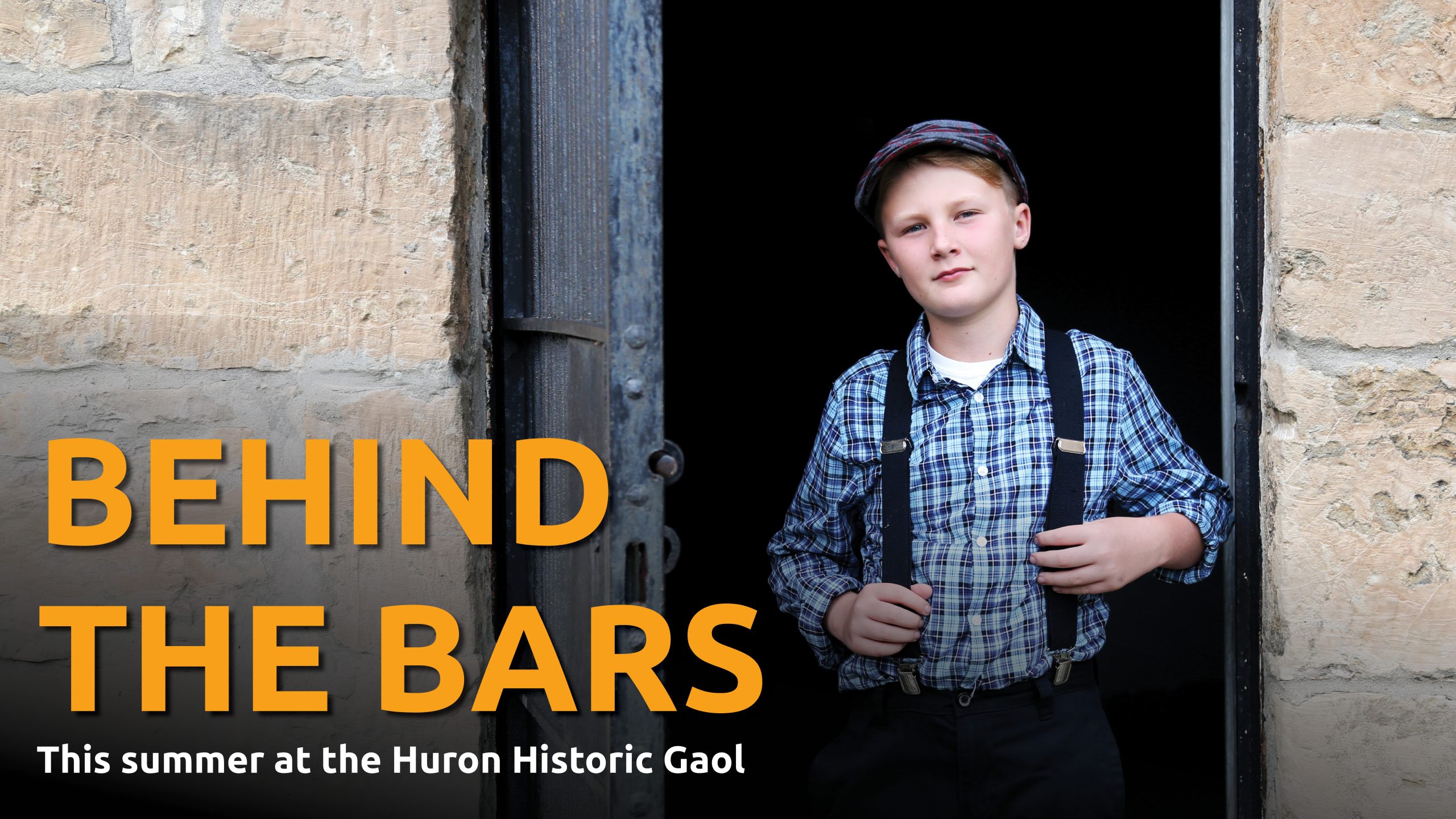 Image of an young male actor dressed in historic costume standing in the Gaol doorway