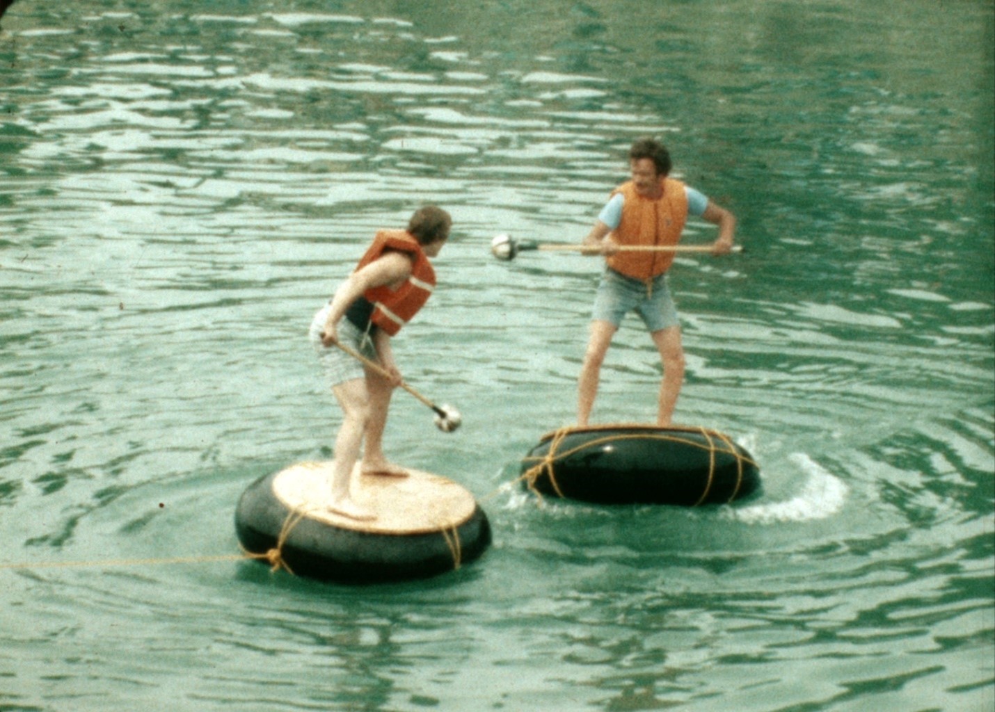 Still of two kids in the water standing on floaties