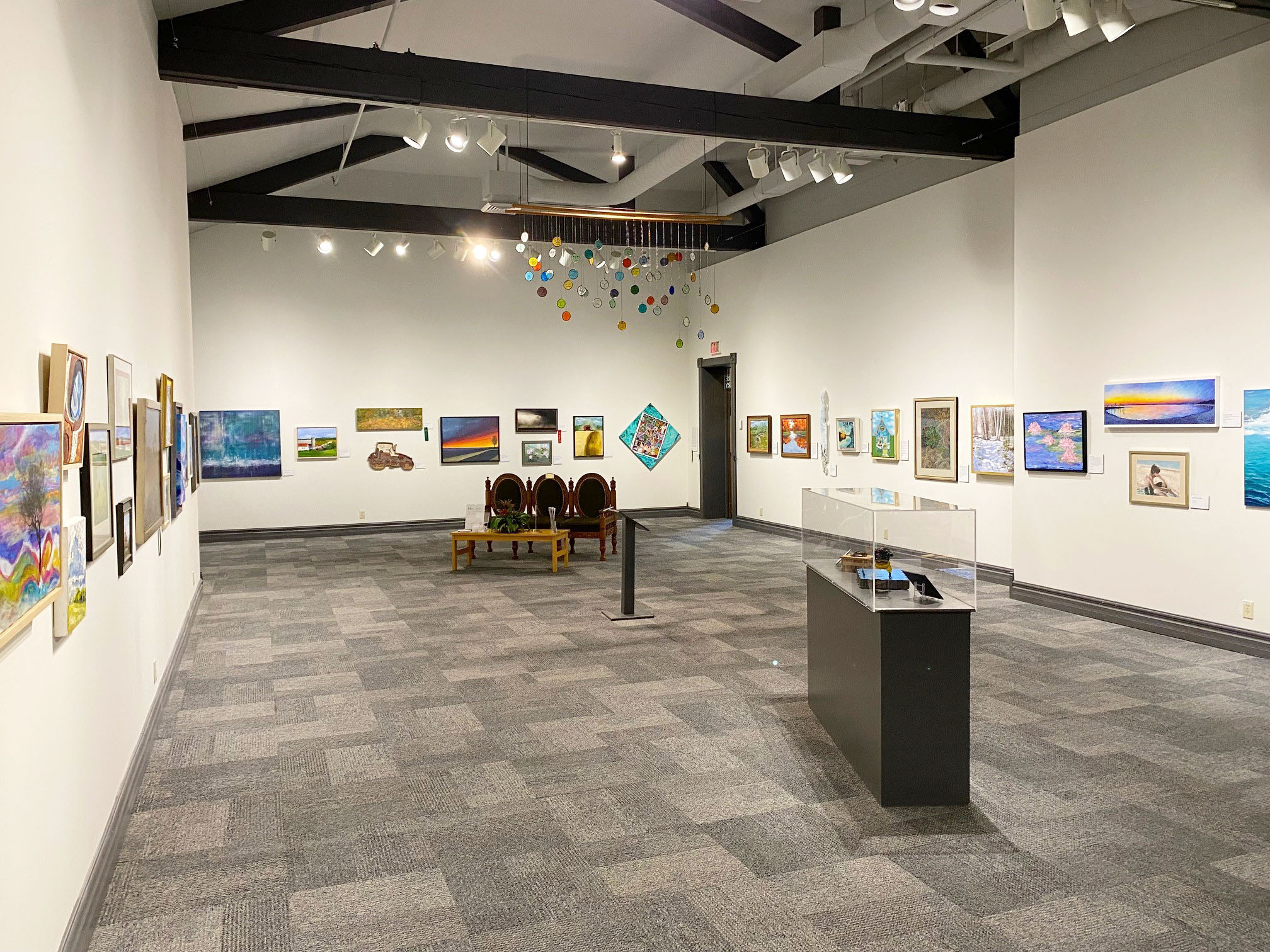 Image of the art show exhibit showing 40+ pieces of art on the walls of the museum's feature gallery